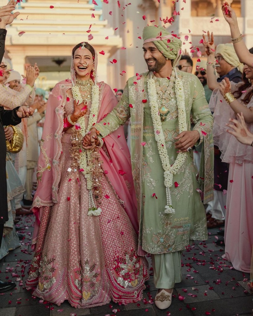 Charming pink and pista green wedding outfits for bride and groom.