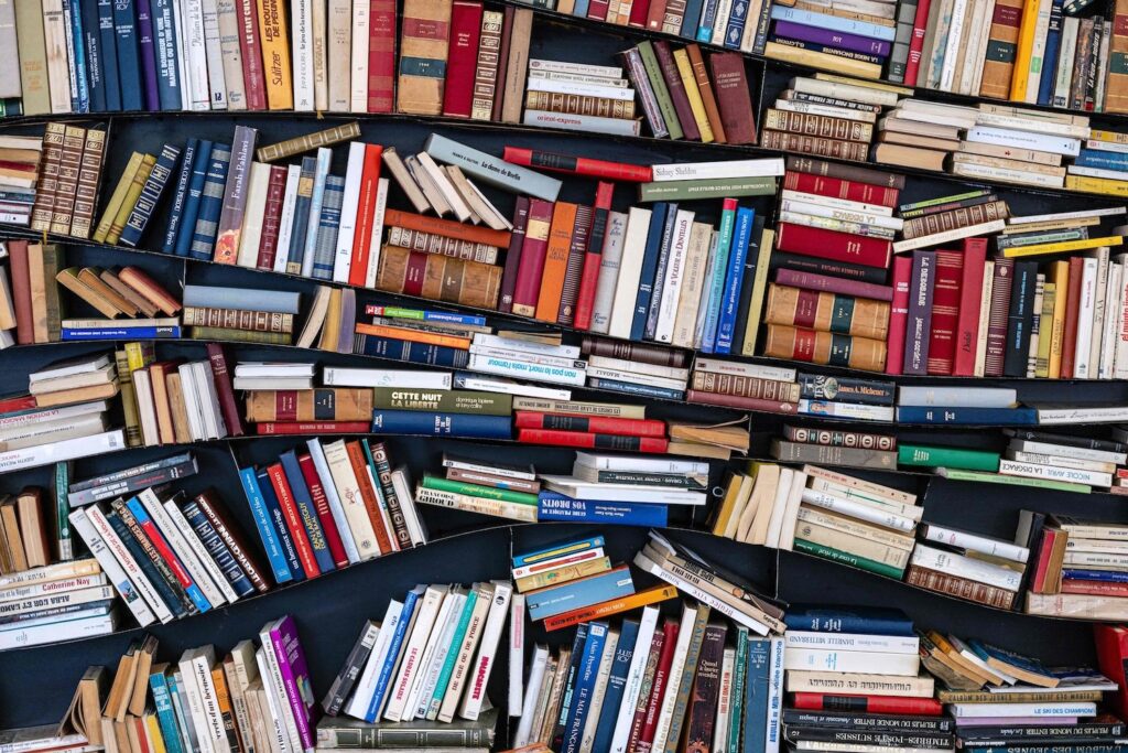 Shelf of unorganized books.