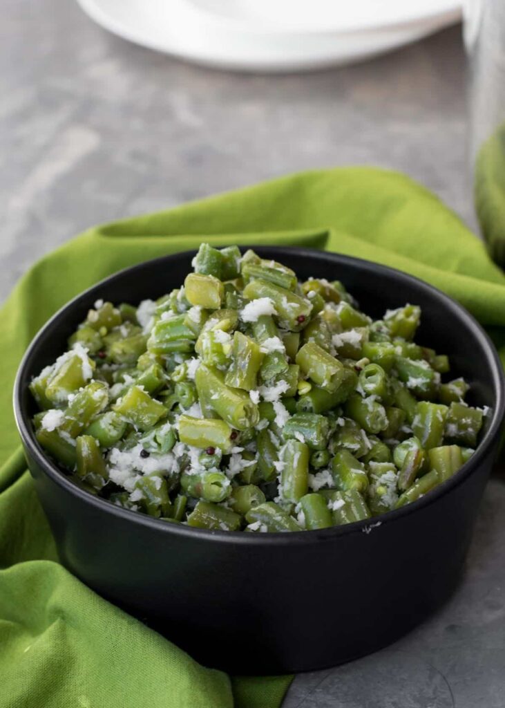 Beans poriyal served in a black bowl.