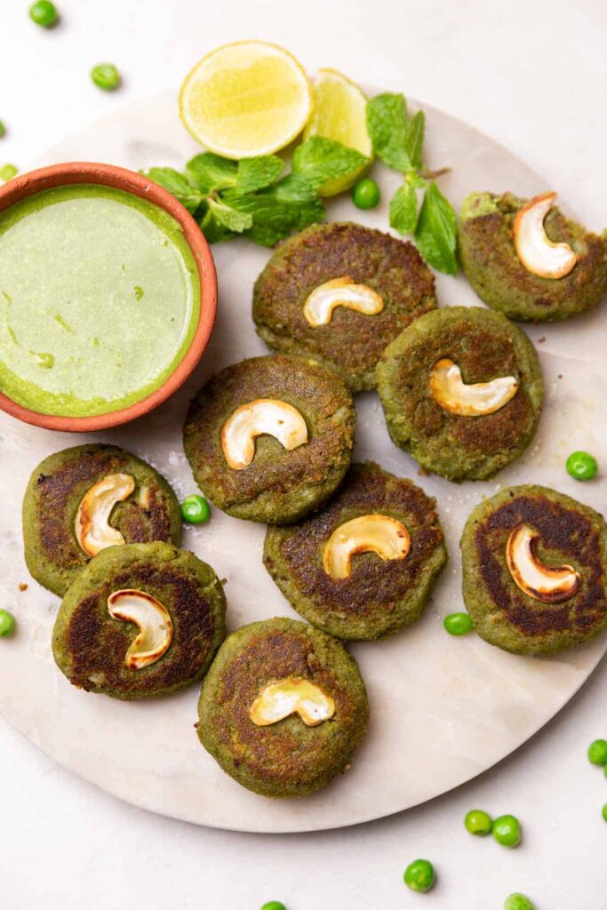 hara bhara kebabs served on a white round platter with accompaniments