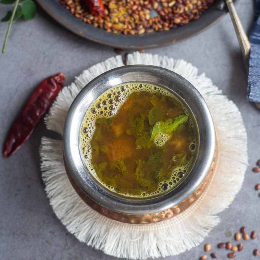 adding all the ingredients for kollu rasam in sauce pan