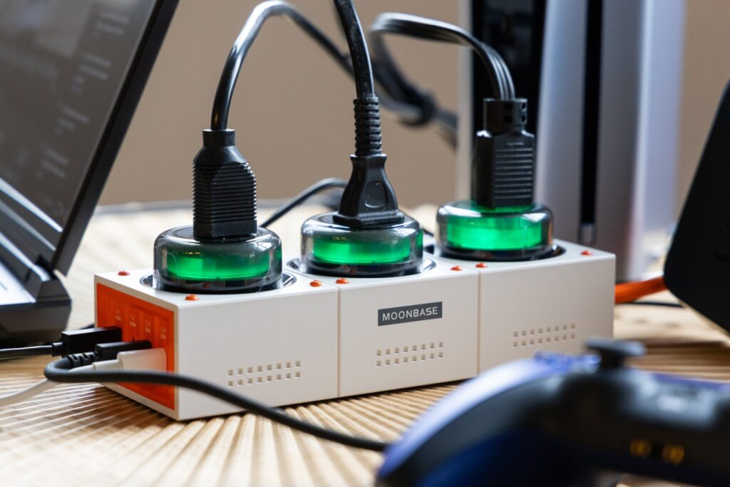 Close up Genki Moonbase Power Strip on table with the AC outlets glowing green