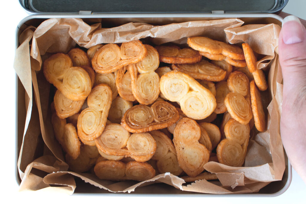 homemade palmier cookies in a tin box