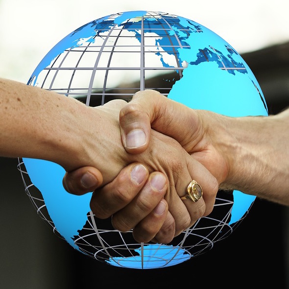 a picture shaking hands with a globe in the background