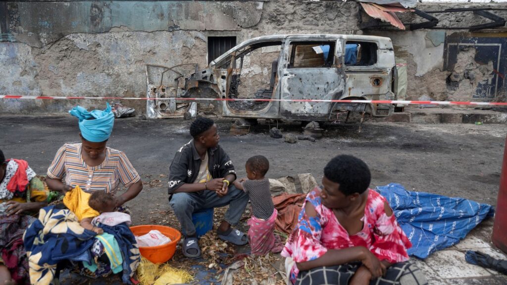 Traders hold a market in front of a vehicle that was hit by fighting between M23 rebels and Congolese forces in eastern Democratic Republic of Congo. Pic: Reuters