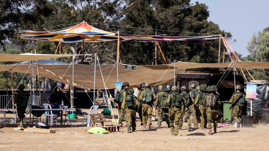 Israeli soldiers walk through the site of an attack on the Nova Festival by Hamas gunmen from Gaza, near Israel's border with the Gaza Strip, in southern Israel, October 12, 2023. REUTERS/Ronen Zvulun