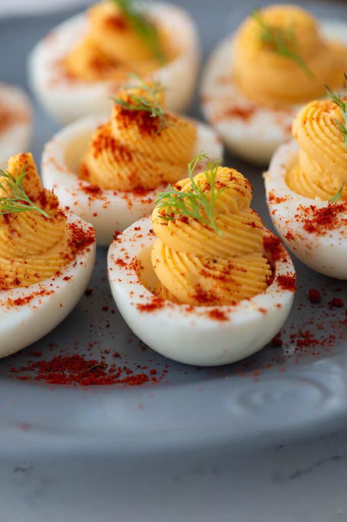 Deviled eggs recipe image. Deviled eggs are topped with paprika and dill
