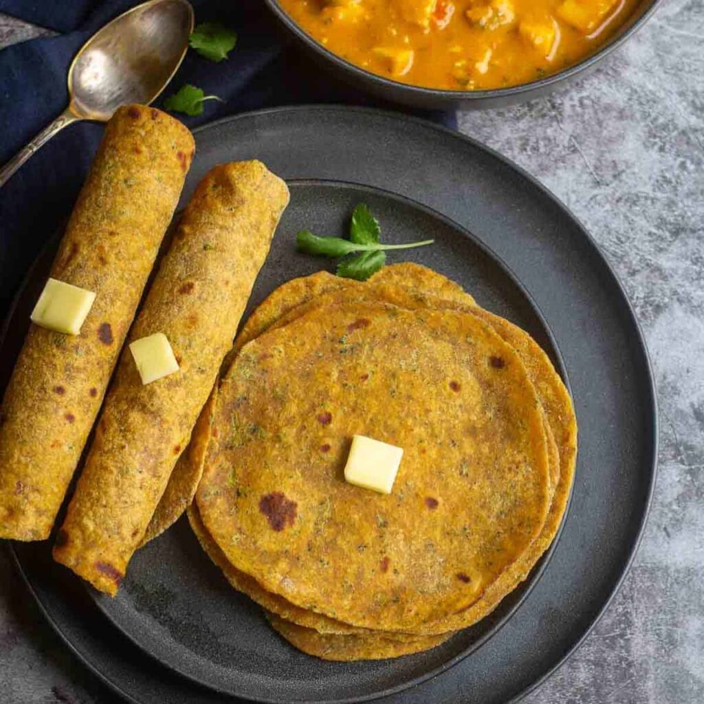 square image overhead shot of broccoli paratha shot and rolled ones on the side