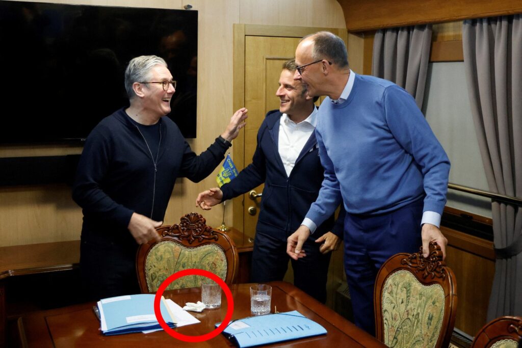 Britain's Prime Minister Keir Starmer (L) gestures during a trilateral meeting France's President Emmanuel Macron (C) and German Chancellor Friedrich Merz (R) on board a train to Kyiv, in Shegyni, Ukraine, on May 9, 2025.